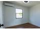 Comfortable bedroom featuring wood floors, mini-split air conditioner, and ample natural light at 9706 N 22Nd St, Tampa, FL 33612