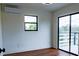 Light-filled bedroom with hardwood floors, AC unit, and access to outdoor deck at 9706 N 22Nd St, Tampa, FL 33612