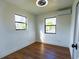 Bright bedroom with hardwood floors, two windows, and an efficient AC unit at 9706 N 22Nd St, Tampa, FL 33612