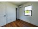 Bedroom featuring wood floors, closet, and window offering outdoor views at 9706 N 22Nd St, Tampa, FL 33612