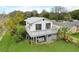 Charming two-story home with a deck and a well-maintained lawn and space for a car underneath the house at 9706 N 22Nd St, Tampa, FL 33612