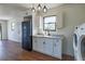 Laundry area showcases white cabinets, sink, modern lighting fixtures, and black refrigerator at 9706 N 22Nd St, Tampa, FL 33612