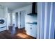 Functional laundry area leading to additional rooms and featuring modern appliances and wood flooring at 9706 N 22Nd St, Tampa, FL 33612