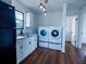 Bright laundry area featuring a washer and dryer hookup, plus a sink, lighting, and luxury laminate flooring at 9706 N 22Nd St, Tampa, FL 33612