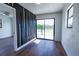 Modern living room features a decorative wall and luxury laminate flooring plus access to deck through glass doors at 9706 N 22Nd St, Tampa, FL 33612
