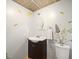 Cozy powder room with decorative mirror, single vanity, and floral wall decor at 10206 N Hyaleah Rd, Tampa, FL 33617
