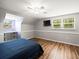Bright bedroom featuring an oversized window, desk, wood floors, and a ceiling fan at 10206 N Hyaleah Rd, Tampa, FL 33617