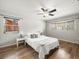 Bright bedroom with hardwood floors, ceiling fan, and large windows at 10206 N Hyaleah Rd, Tampa, FL 33617