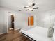 Bedroom featuring hardwood floors, ceiling fan, and an attached bathroom at 10206 N Hyaleah Rd, Tampa, FL 33617