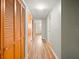 Hallway with hardwood flooring and multiple wooden closets that offer storage space at 10206 N Hyaleah Rd, Tampa, FL 33617