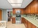 Well-lit kitchen boasts stainless steel appliances, granite counters, tile backsplash, and wood cabinets at 10206 N Hyaleah Rd, Tampa, FL 33617