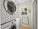 Bright laundry room with stacked washer/dryer, window, tile floors and storage at 10206 N Hyaleah Rd, Tampa, FL 33617