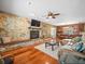 Spacious living room with a stone fireplace and hardwood floors, perfect for entertaining at 10206 N Hyaleah Rd, Tampa, FL 33617