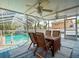 Covered patio featuring ceiling fans, a dining area, and a view of the sparkling in-ground swimming pool at 10206 N Hyaleah Rd, Tampa, FL 33617