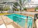 Screened-in pool area with safety fence and view of shed and backyard at 10206 N Hyaleah Rd, Tampa, FL 33617
