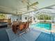 Covered patio with outdoor seating overlooking the sparkling screened-in pool at 10206 N Hyaleah Rd, Tampa, FL 33617