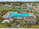 Aerial shot of a community pool and clubhouse featuring lounge chairs, landscaping, and palm trees at 10433 Alder Green Dr, Riverview, FL 33578
