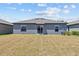 View of home's backyard and exterior featuring a grass lawn at 10433 Alder Green Dr, Riverview, FL 33578