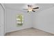 Bright, minimalist bedroom with a ceiling fan, window, closet, and neutral carpet at 10433 Alder Green Dr, Riverview, FL 33578