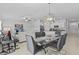 Open-concept dining room with a modern chandelier and view of the living room at 10433 Alder Green Dr, Riverview, FL 33578