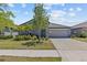 Charming single-story home with a well-manicured lawn, lush landscaping, and an attached two-car garage at 10433 Alder Green Dr, Riverview, FL 33578