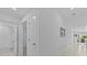 Bright hallway leading to a bathroom and dining area, featuring tile flooring and neutral decor at 10433 Alder Green Dr, Riverview, FL 33578