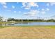 Scenic view of a tranquil pond reflecting the sky, with lush greenery on the banks and modern buildings in the background at 10433 Alder Green Dr, Riverview, FL 33578