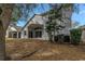 Backyard featuring a spacious yard, mature trees, and partial view of the home's exterior at 10506 Sky Flower Ct, Land O Lakes, FL 34638