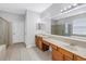 Bright bathroom featuring double sinks, a large mirror, and a separate glass-enclosed shower at 10506 Sky Flower Ct, Land O Lakes, FL 34638