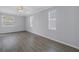 Bedroom with wood flooring, neutral walls, and windows allowing for natural light and backyard views at 10506 Sky Flower Ct, Land O Lakes, FL 34638