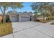 Spacious three-car garage, wide driveway and manicured front yard in a suburban neighborhood at 10506 Sky Flower Ct, Land O Lakes, FL 34638
