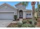 Welcoming home featuring an arched entryway supported by grand columns with an attached two car garage at 10506 Sky Flower Ct, Land O Lakes, FL 34638