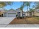 Charming single-story home with a well-manicured lawn, mature landscaping, and an attached two-car garage at 10506 Sky Flower Ct, Land O Lakes, FL 34638