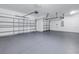 Spacious two-car garage with a gray painted floor and white walls, ready for storage or projects at 10506 Sky Flower Ct, Land O Lakes, FL 34638