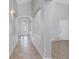 Long hallway with tile floors, arched openings, and a view of the decorative glass front door at 10506 Sky Flower Ct, Land O Lakes, FL 34638