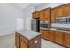 Kitchen featuring a center island, stainless steel appliances, and warm-toned wooden cabinetry at 10506 Sky Flower Ct, Land O Lakes, FL 34638