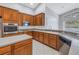 Beautiful kitchen featuring rich wood cabinetry, stainless steel appliances, granite countertops, and a functional layout at 10506 Sky Flower Ct, Land O Lakes, FL 34638