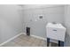 Functional laundry room with a utility sink, tiled floor, and storage shelving at 10506 Sky Flower Ct, Land O Lakes, FL 34638