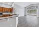 Open concept living area with wood floors, kitchen access, and lake views from large windows at 10506 Sky Flower Ct, Land O Lakes, FL 34638