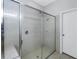 Glass-enclosed shower with tile surround, bench, and a doorway leading to another room at 10506 Sky Flower Ct, Land O Lakes, FL 34638