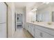 Bathroom featuring a double vanity, shower, and view of the bedroom at 10998 Gable Dig Loop, San Antonio, FL 33576