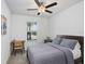 Cozy bedroom featuring a wooden bed frame, a ceiling fan, and a view of the street at 10998 Gable Dig Loop, San Antonio, FL 33576