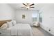 Serene bedroom with large windows, neutral color palette, ceiling fan, and a comfortable seating area at 10998 Gable Dig Loop, San Antonio, FL 33576