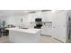 Modern kitchen with white cabinets, stainless steel appliances, and a center island at 10998 Gable Dig Loop, San Antonio, FL 33576