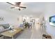 Inviting living room and kitchen featuring stainless steel appliances, light wood floors, and an island at 10998 Gable Dig Loop, San Antonio, FL 33576