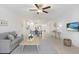 Bright living room with light wood floors, neutral decor, and a ceiling fan at 10998 Gable Dig Loop, San Antonio, FL 33576