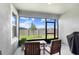 A screened patio featuring a table with chairs and view of backyard at 10998 Gable Dig Loop, San Antonio, FL 33576