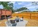 The cozy backyard has a seating area with modern chairs, fire pit, and a wooden fence for privacy at 1111 32Nd N St, St Petersburg, FL 33713