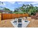 The backyard features a cozy seating area with modern chairs, and a wooden fence for privacy at 1111 32Nd N St, St Petersburg, FL 33713