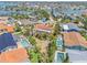 Aerial view of a single-Gathering home featuring a screened pool, lush landscaping, and a waterfront location at 1141 80Th Street S Ct, St Petersburg, FL 33707